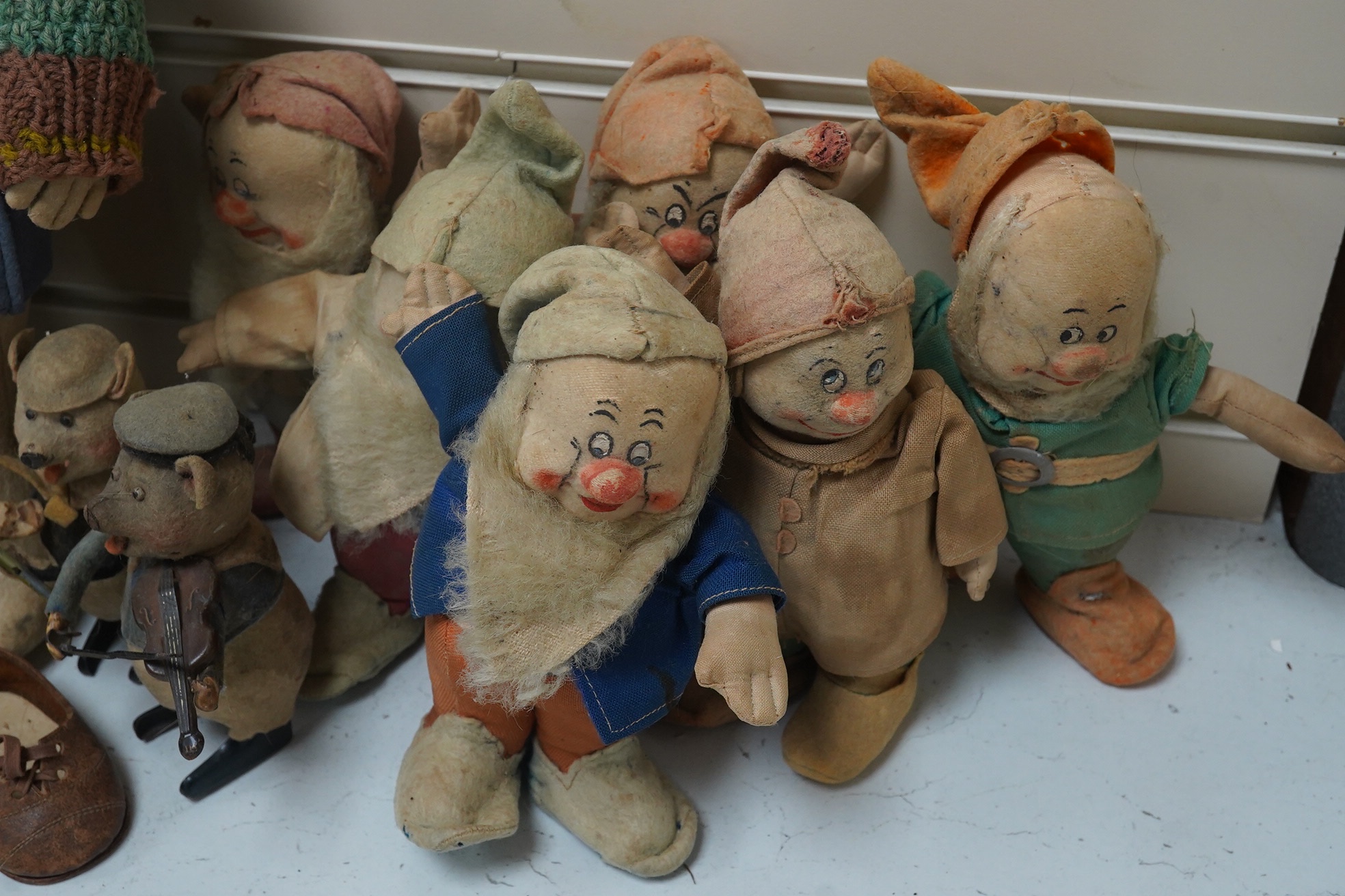 A Merrythought Hygienic Toys Snow White and the seven dwarves, three Schuco clockwork pig musicians and a felt doll. Condition - fair.